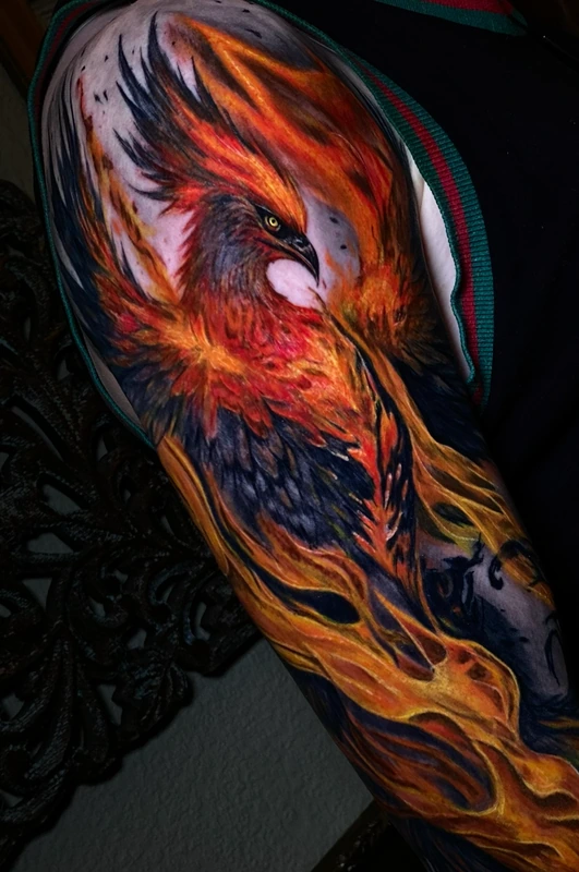 Fênix tatuada em cores vibrantes no braço